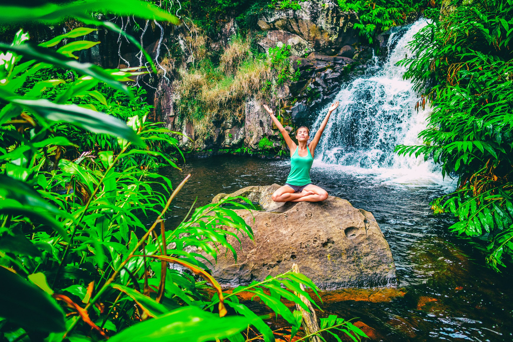 Yoga Nature Wellness Meditation Retreat Woman at Tropical Waterfall Forest in Kauai, Hawaii. Happy Girl with Open Arms in Serenity Enjoying Lush Outdoors, Mindfulness Concept